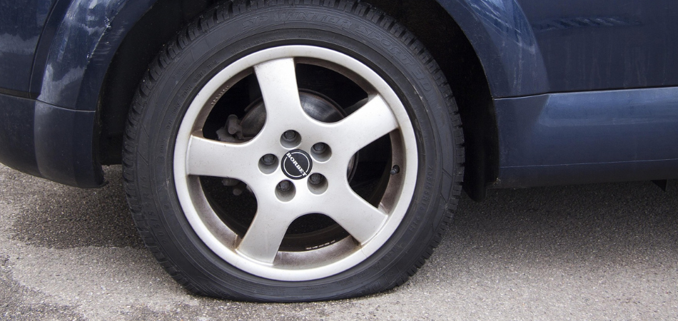 A blue car with a flat tire