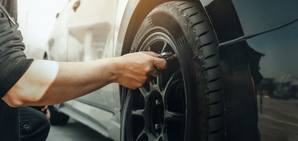 A person putting air on their car tire